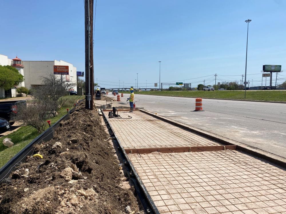 Crews install a new shared-use path next to US 290 near Monterey Oaks Boulevard. Fourteen miles of new shared-use paths or sidewalks will be installed along the project corridor as part of the new Oak Hill Parkway. April 2022